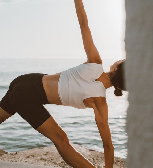 Person stretching during sunrise, symbolizing energy and renewal.